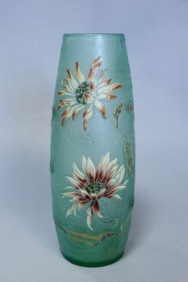 un vase en verre sur lequel sont peintes des fleurs sur un fond blanc