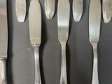six forks and a knife on the table