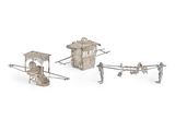 trois figurines en métal argenté représentant des personnages et un petit bâtiment