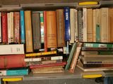 a plastic box filled with books on the floor