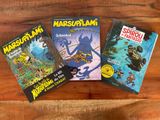 trois livres pour enfants posés sur une table en bois
