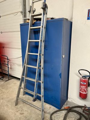 une échelle appuyée contre une armoire bleue dans un garage