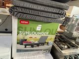 a stack of sunloungerr and a washing machine in a store