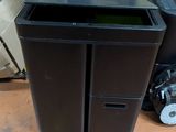 a black trash can sitting next to a black trash can