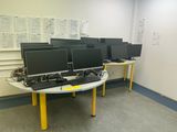 many computer screens on the table in the room