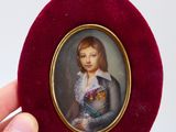 un portrait miniature représentant une jeune fille, dans un écrin rouge