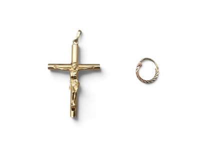 a gold cross and a ring on a white surface