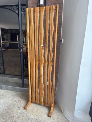 a tall wooden stand with a vase on top of it