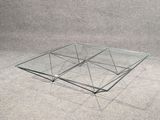une image représentant une table basse en verre sur fond gris