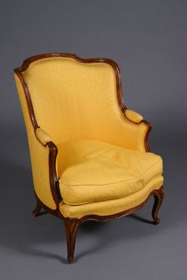 a yellow chair sitting on top of a wooden floor next to a gray wall