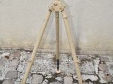 a tripod on the ground next to a wall