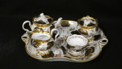 a tray with a tea set on it on a black background