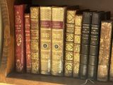 many old books on a shelf in a book case
