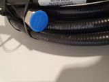 a close up of a black hose with a blue button on it