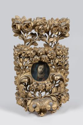 un cadre doré richement décoré, dans lequel figure le portrait d'une femme entourée de fleurs et de feuilles
