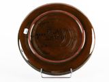 a brown plate with writing on it sitting on a stand