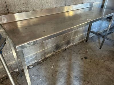 une table en acier inoxydable au milieu d'une pièce