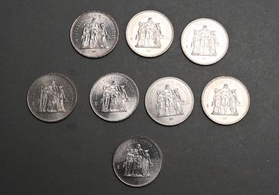 six types différents de pièces d'argent sur une surface noire