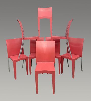 six chaises rouges disposées en cercle sur un fond gris