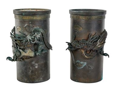 pair of bronze vases with dragon heads on them on a white background