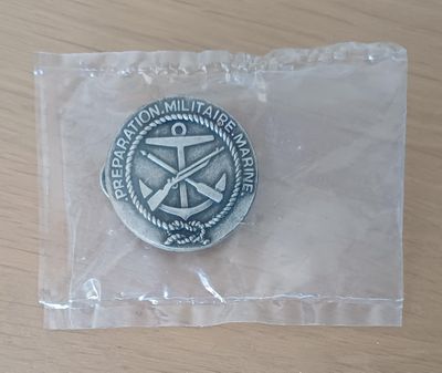 une médaille d'argent posée sur un sac en plastique posé sur une table