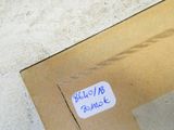 une boîte sur laquelle est collé un autocollant, posée par terre