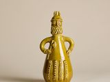 figurine en céramique jaune représentant un homme coiffé d'un chapeau