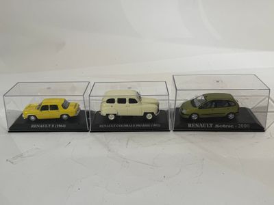 trois voitures miniatures sont exposées dans une vitrine posée sur une surface blanche