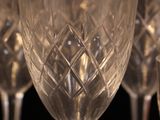 several empty wine glasses are lined up on a black surface