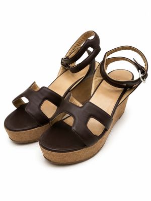 Les sandales à talons compensés pour femme sont en cuir et comportent deux lanières.