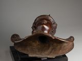 bronze sculpture of a woman ' s head on a wooden base