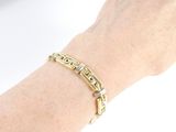 bracelet on a woman ' s arm with a gold chain and a diamond clasp