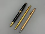 three different types of pens sitting next to each other on a table