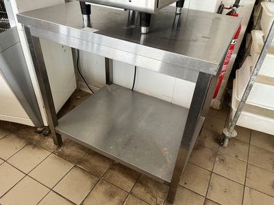 une table en acier inoxydable avec deux chaises dessus