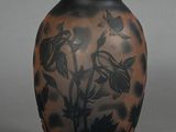 a black and brown vase with flowers on it