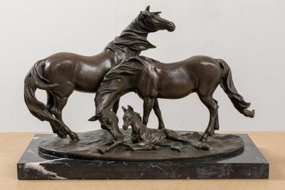 bronze statue of two horses on a marble base on a table