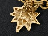 a gold necklace with a star on it on a black surface