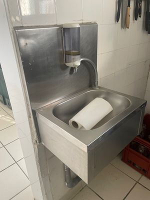 un évier en métal dans lequel se trouve un rouleau de papier toilette