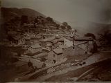 a black and white photo of a village in the mountains
