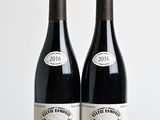 deux bouteilles de vin posées sur une table l'une à côté de l'autre