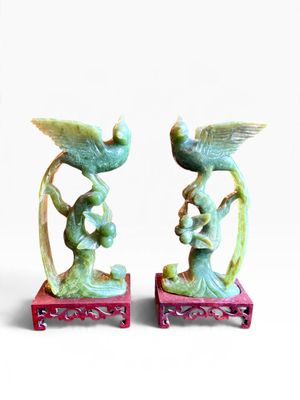 deux figurines posées sur un socle rouge