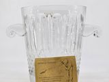 a clear glass vase with a gold label on it