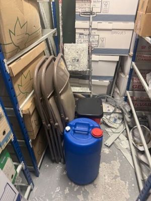 a blue barrel sitting next to a stack of chairs in a room
