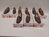 Six paires de chaussures marron sont exposées dans une vitrine.