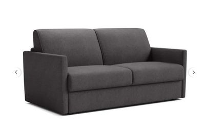 a gray couch with a black foot rest and a white background