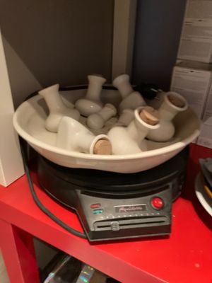 un bol rempli de vases blancs posé sur une étagère rouge
