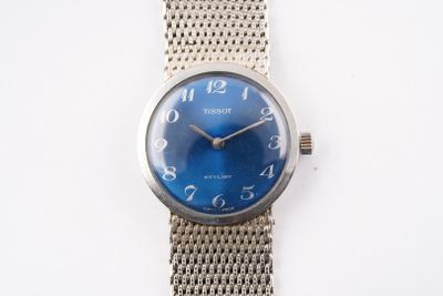 une image d'un gros plan d'une montre-bracelet sur une surface blanche