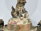 a large vase that has a dog on top of it