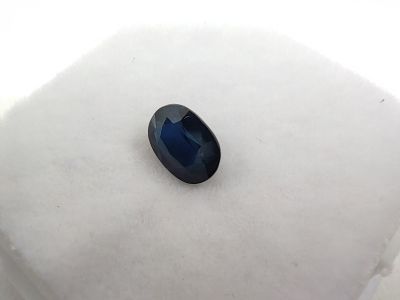 a close up of a blue sapphire stone on a white surface