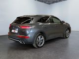 the rear end of a grey car in a white room